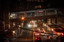 Mitarbeitende eines Krankenhauses überqueren eine Straße in einer Überführung am Makati Medical Center in Manila.