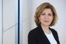 Joumana Seif blickt vor einem neutralen Hintergrund in die Kamera